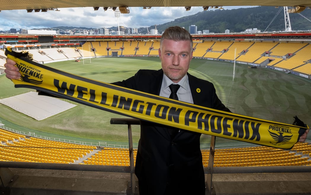 New head coach of the Wellington Phoenix Ufuk Talay holds a Phoenix scarf at Westpac Stadium.