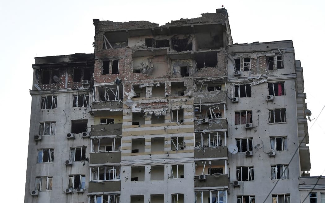 A photograph shows a multi-storey residential building, partially destroyed after night drone attacks in Kyiv on May 30, 2023. Ukraine on May 30, 2023 said it had downed 29 out of 31 drones, mainly over Kyiv and the Kyiv region in the latest Russian barrage -- the third on the capital in 24 hours. (Photo by Sergei SUPINSKY / AFP)