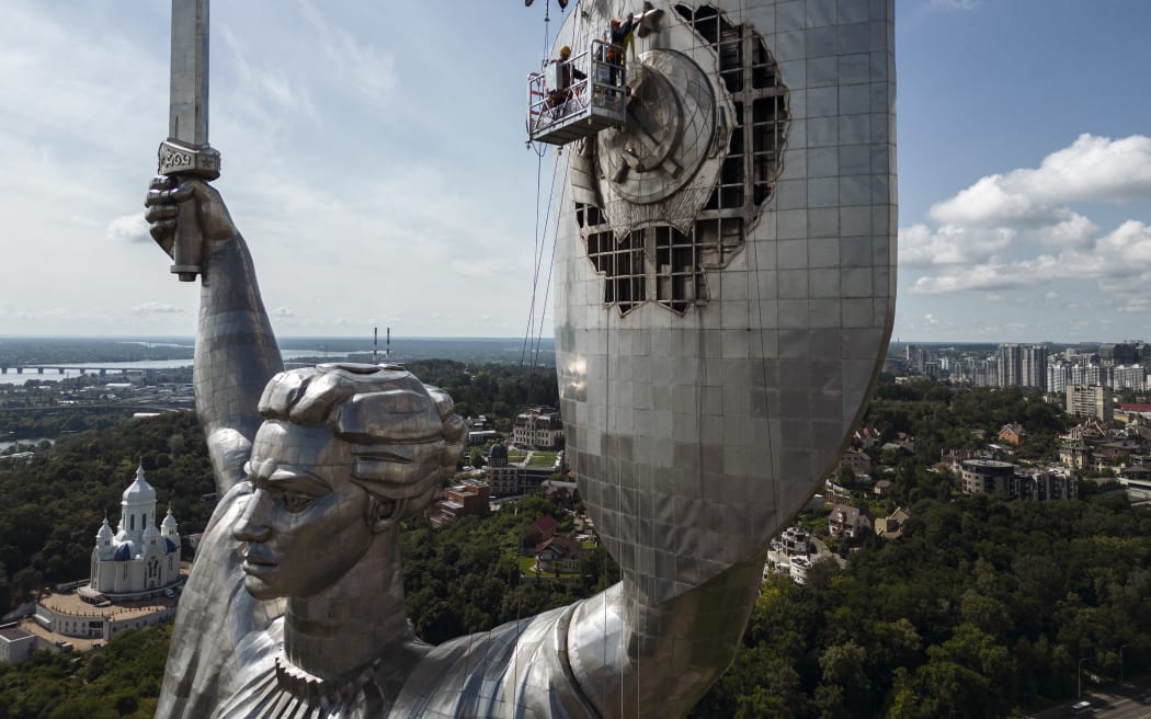 Workers dismount a Soviet coat of arms from the shield of the Motherland monument at a compound of the World War II museum in Kyiv, Ukraine August 1, 2023 (Photo by Maxym Marusenko/NurPhoto) (Photo by Maxym Marusenko / NurPhoto / NurPhoto via AFP)