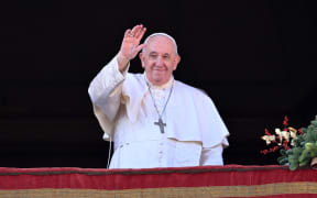 (FILES) Pope Francis waves to the crowd as he appears at the balcony to deliver his Christmas Urbi et Orbi blessing in St. Peter's Square at The Vatican on December 25, 2022.  The Vatican on December 12, 2023 approved blessings for same-sex couples but insisted they must not be established as a Catholic rite nor given in contexts related to civil unions or weddings. In a document approved by Pope Francis, the Vatican backed "the possibility of blessings for couples in irregular situations and for couples of the same sex" but "this blessing should never be imparted in concurrence with the ceremonies of a civil union, and not even in connection with them". (Photo by Andreas SOLARO / AFP)
