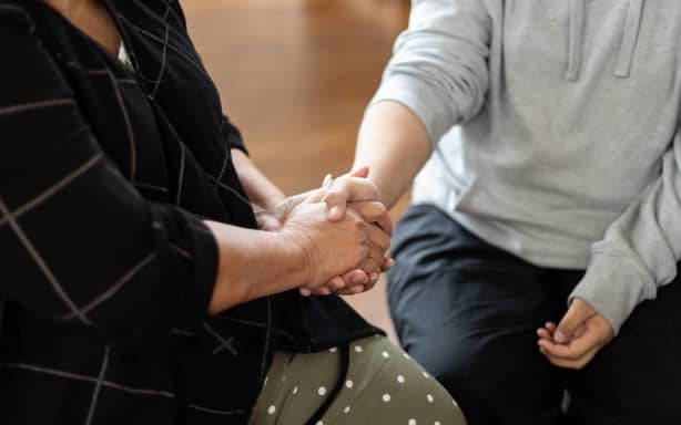 A close up of two people holding hands