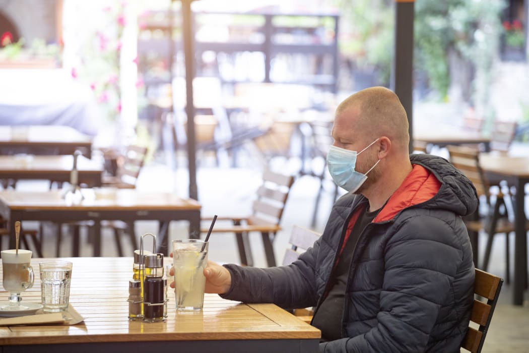 Man in restaurant wearing face mask to protect against Covid-19.