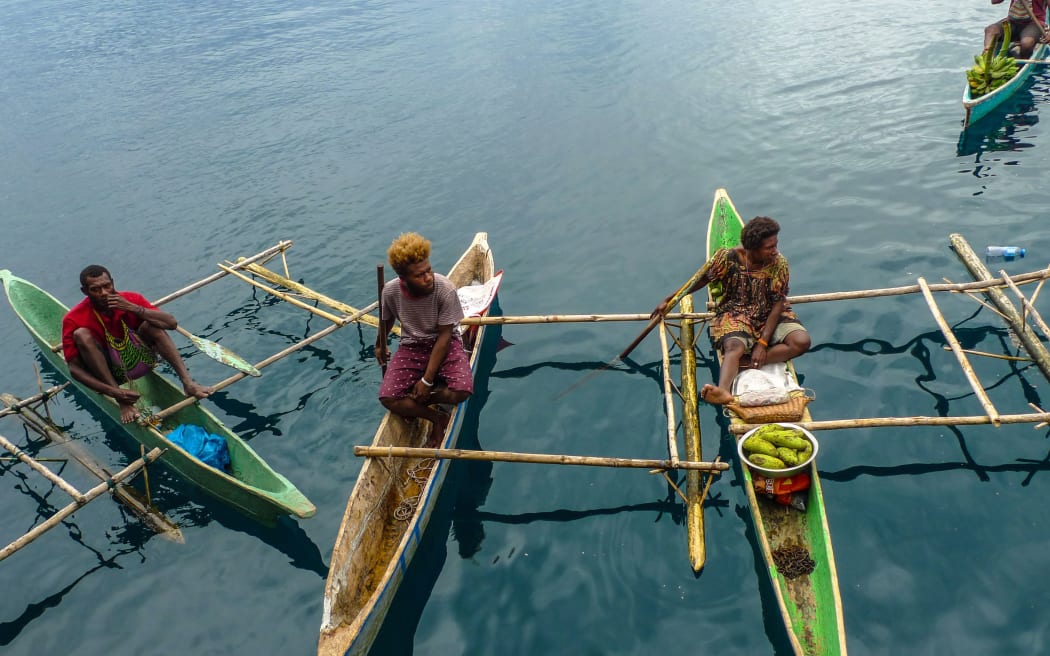 Traders by the vessels side in Papua New Guinea.