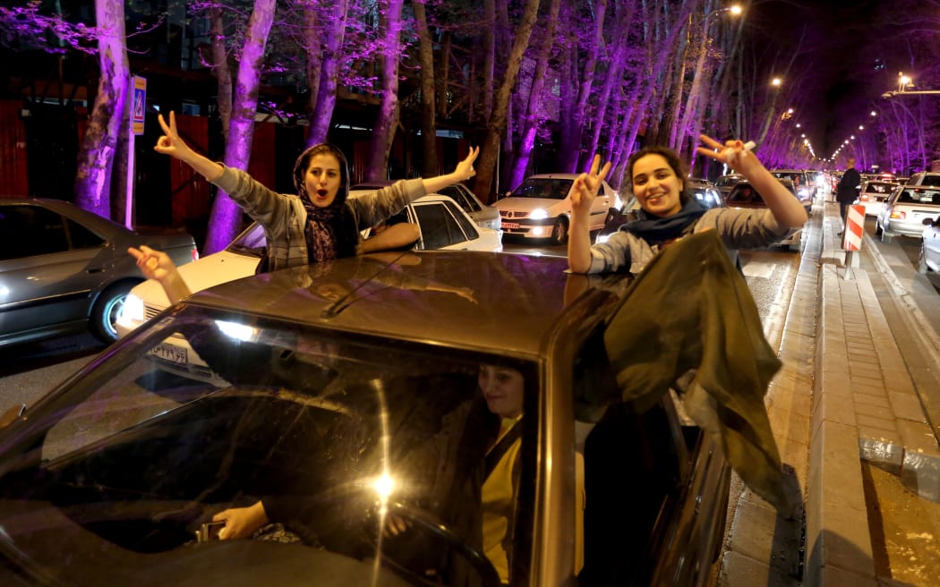 Women sitting in a car flash the "V for Victory" sign as they celebrate on Valiasr street in northern Tehran.
