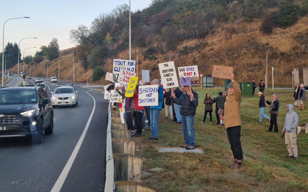 Protesters line a Queenstown highway calling on the Queenstown Lakes District Council to ditch plans to dump treated sewage into the Shotover River.