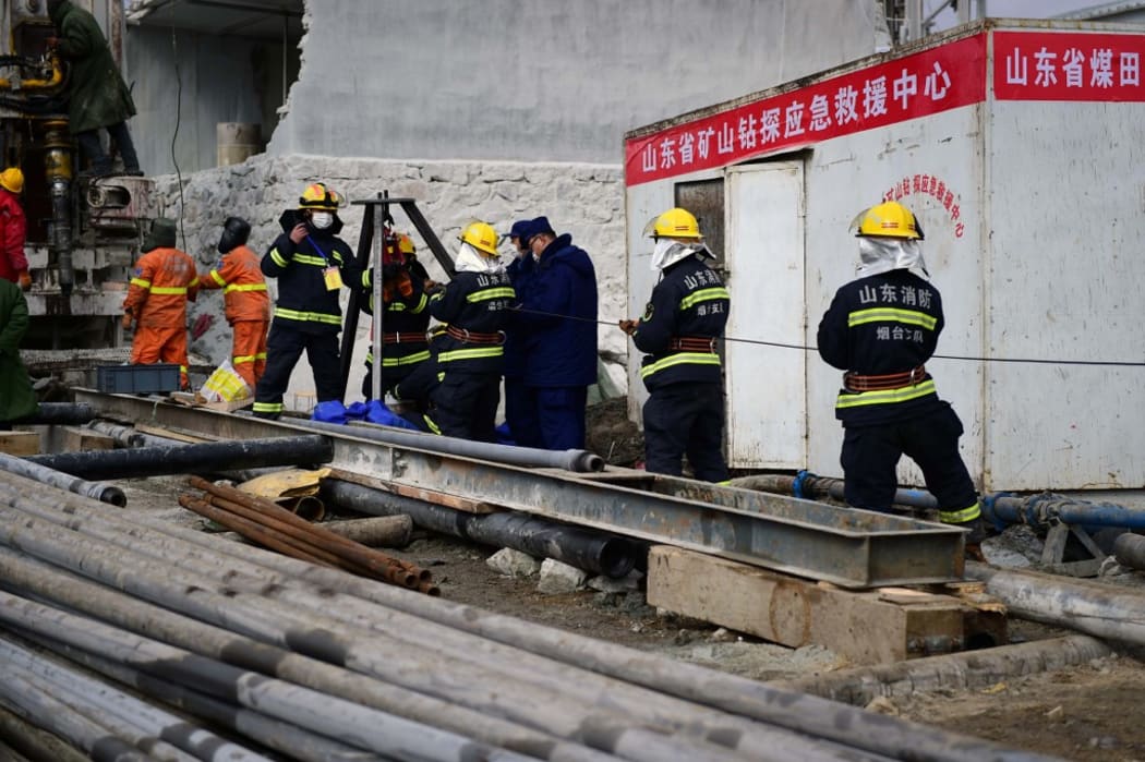 This photo taken on January 20, 2021 shows members of a rescue team working at the site of a gold mine explosion where 22 miners are trapped underground in Qixia, in eastern China's Shandong province.