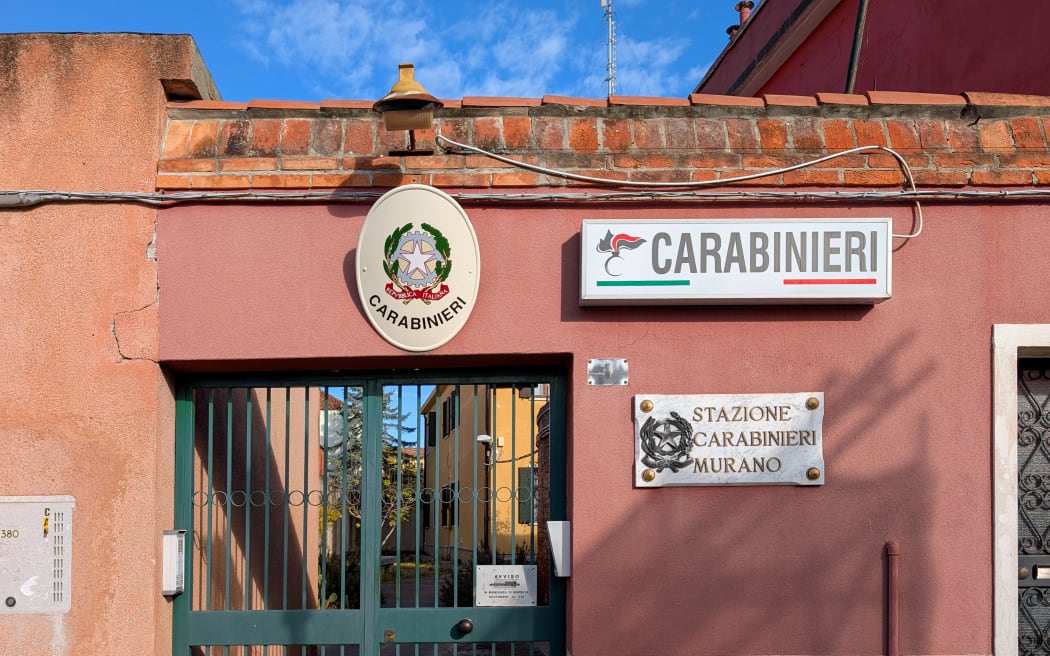 A Carabinieri police station has a sign mounted on the station building in a residential neighborhood on Murano Island in Murano, Venice Province, Veneto, Italy, on November 18, 2025. The scene documents the presence of Italian police and island police service, which is essential to daily life on Murano Island in the Venice Lagoon. (Photo by Michael Nguyen/NurPhoto) (Photo by Michael Nguyen / NurPhoto via AFP)