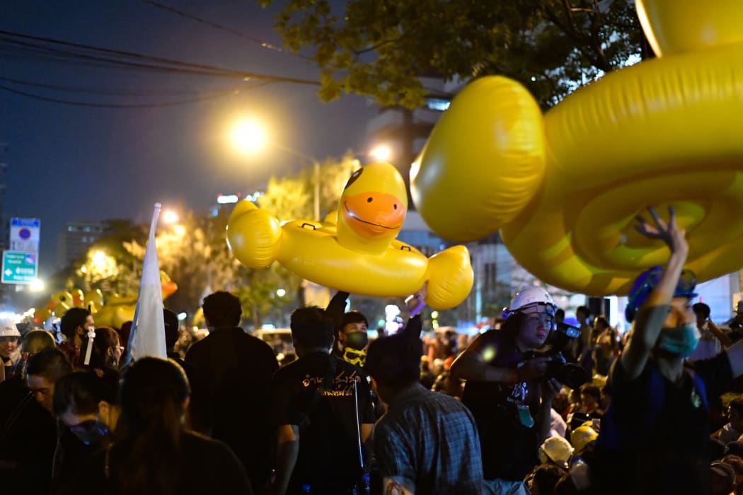 Pro-democracy protesters move inflatable rubber ducks during an anti-government rally outside the Royal Thai Police Headquarters.