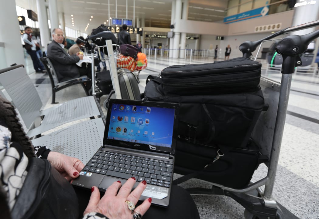 Woman at Beirut international airport checking laptop. March 2017.