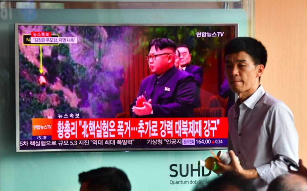 People watch a television news report, showing file footage of North Korean leader Kim Jong-Un, at a railway station in Seoul on September 9, 2016. North Korea claimed September 9 it has successfully tested a nuclear warhead that could be mounted on a missile,