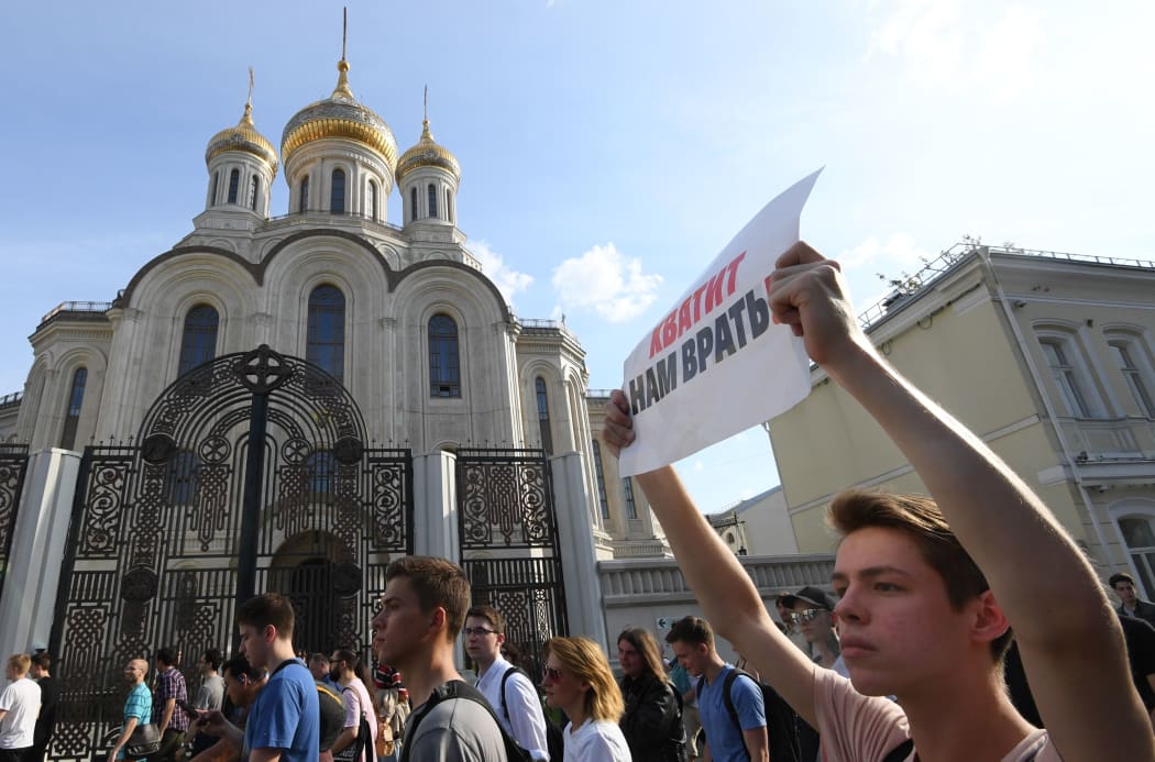 A protester carries a placard reading "Stop lying to us" during an unauthorised rally demanding independent and opposition candidates be allowed to run for office