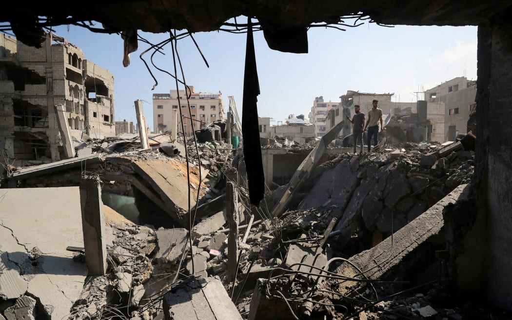 Palestinians inspect the site of an Israeli strike that damaged and destroyed residential buildings, at Shati refugee camp, in Gaza City, 4 July.