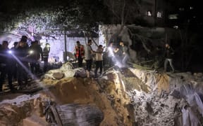 People search with flashlights by an impact crater at the site of a building that was hit by Israeli bombardment in Rafah in the southern Gaza Strip on May 7, 2024 amid the ongoing conflict in the Palestinian territory between Israel and the militant group Hamas.