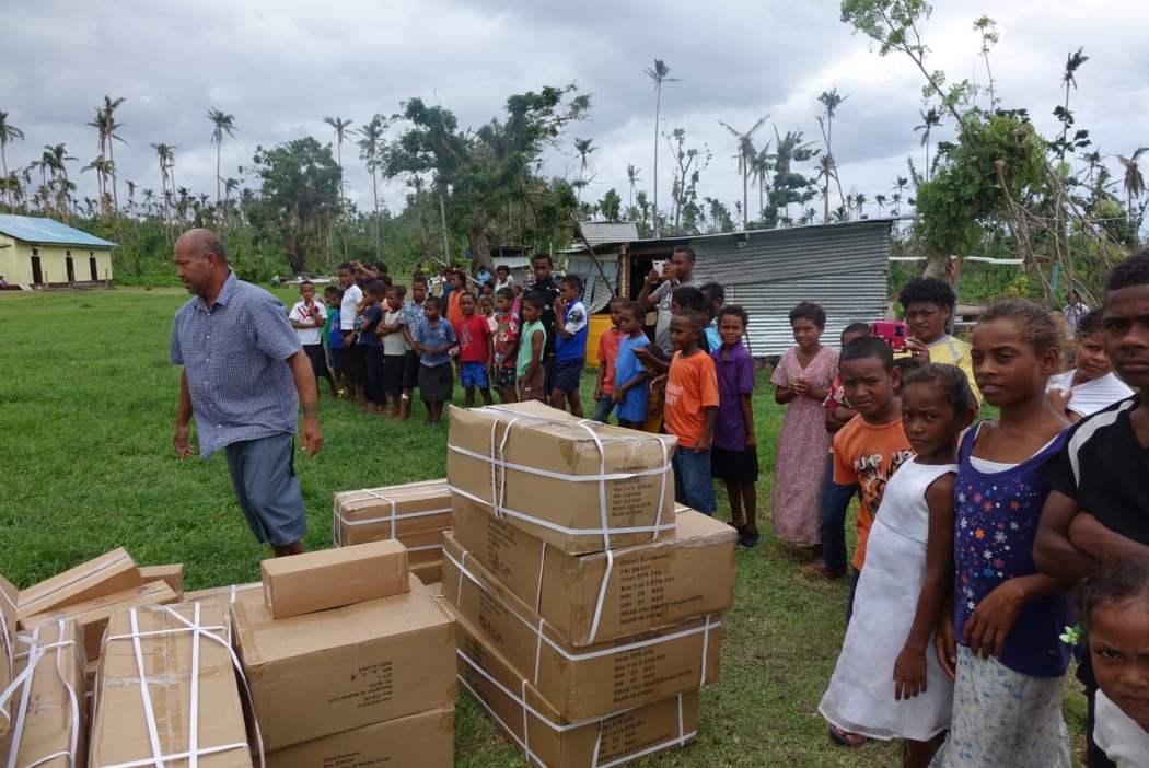 Villagers on Taveuni watch as more tents are unloaded. It is the first aid they have received since Cyclone Winston