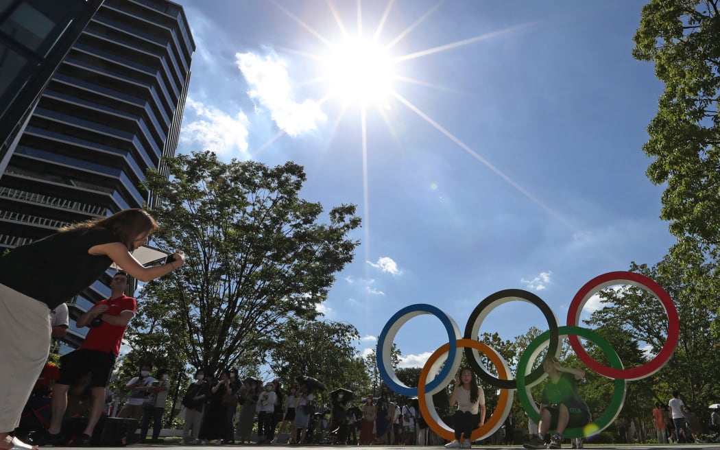 People gather to take photos with 5 rings Olympic mark in front of National Stadium in Shinjuku Ward, Tokyo On August 4, 2021. According to the Japan Meteorological Agency, the highest temperature rose to 34.5 Celsius (94.1 Fahrenheit).     ( The Yomiuri Shimbun ) (Photo by Ryoichiro Kida / Yomiuri / The Yomiuri Shimbun via AFP)