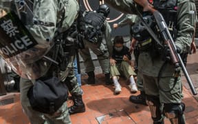Riot police detain a woman as they clear protesters taking part in a rally against a new national security law in Hong Kong on July 1, 2020, on the 23rd anniversary of the city's handover from Britain to China.