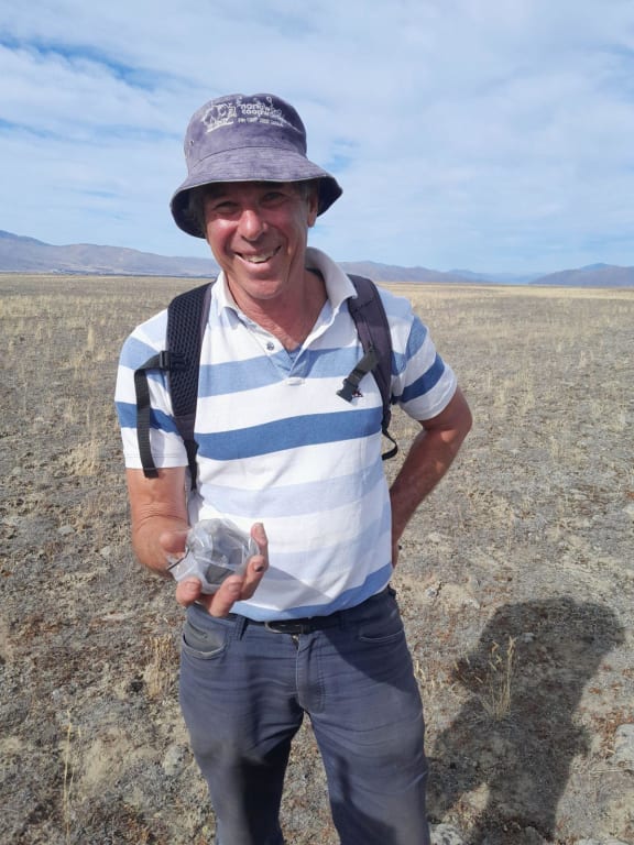 Fireballs Aotearoa citizen scientist Steve Wyn-Harris holding onto the rock after it has been packaged up to protect from hands and the environment.