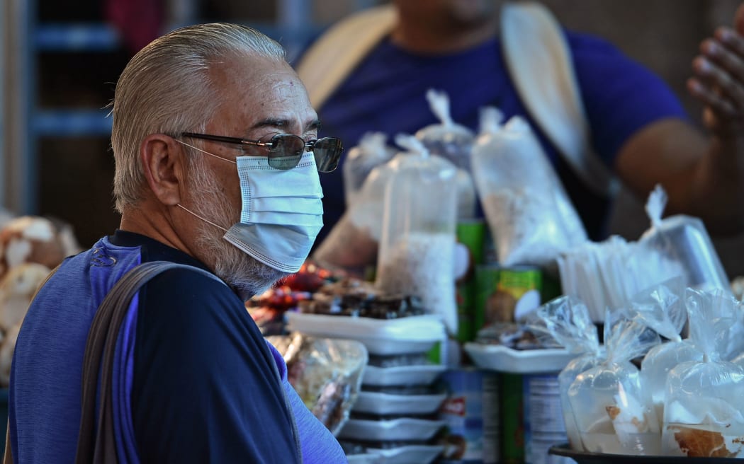 A man wears a protective face mask to prevent the spread of the new Coronavirus, at the Agriculture Market, in Tegucigalpa, on March 14, 2020. -