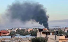 Smoke billows over buildings in Deir el-Balah in the central Gaza Strip, during Israeli bombardment on January 10, 2024, amid ongoing battles between Israel and the Palestinian militant group Hamas. (Photo by AFP)