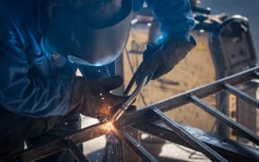 worker with protective mask welding metal