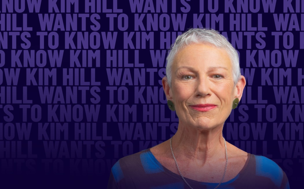 A woman with short grey hair half-smiles in front of a background of faint repeating text reading "Kim Hill Wants to Know"