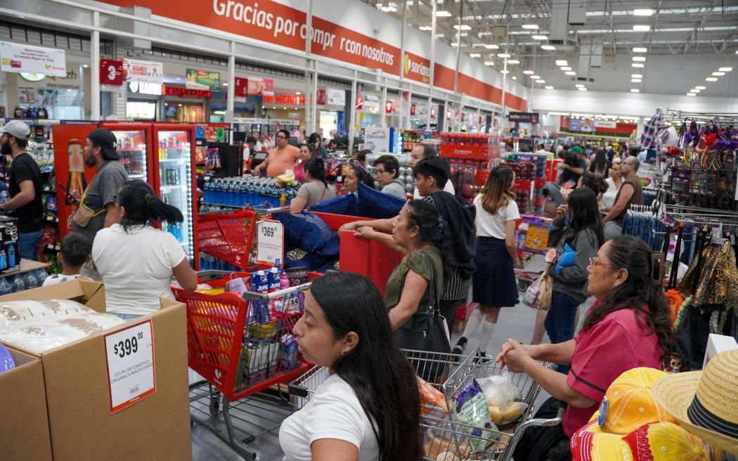 People queue to buy groceries at a store ahead of Hurricane Milton's arrival in Cancun, Quintana Roo State, Mexico, on October 7, 2024. - Hurricane Milton exploded in strength Monday to become a potentially catastrophic Category 5 storm bound for Florida, threatening the US state with a second ferocious storm in as many weeks. Milton, which is also forecast to graze Mexico's Yucatan peninsula as it churns eastward, rapidly intensified to the highest category on a scale of five, triggering evacuation orders and alarms about a life-threatening storm surge in major population centers, including Tampa Bay. (Photo by ELIZABETH RUIZ / AFP)