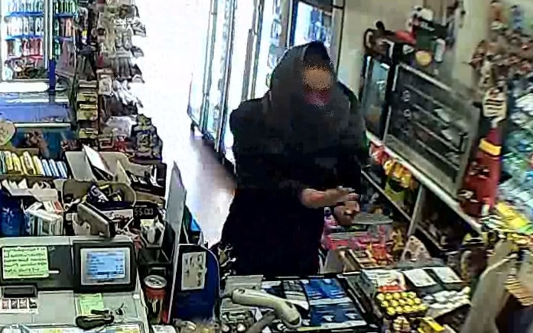 A man holding a weapon at the 10 O'Clock Dairy in St Kilda before a smoke cannon was set off.
