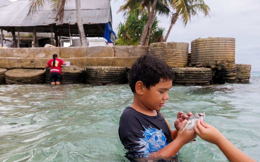 Pesi's cousin 9-year-old Tehoa Lui with Turtle 'Popo' going for their daily swim in Tokelau.