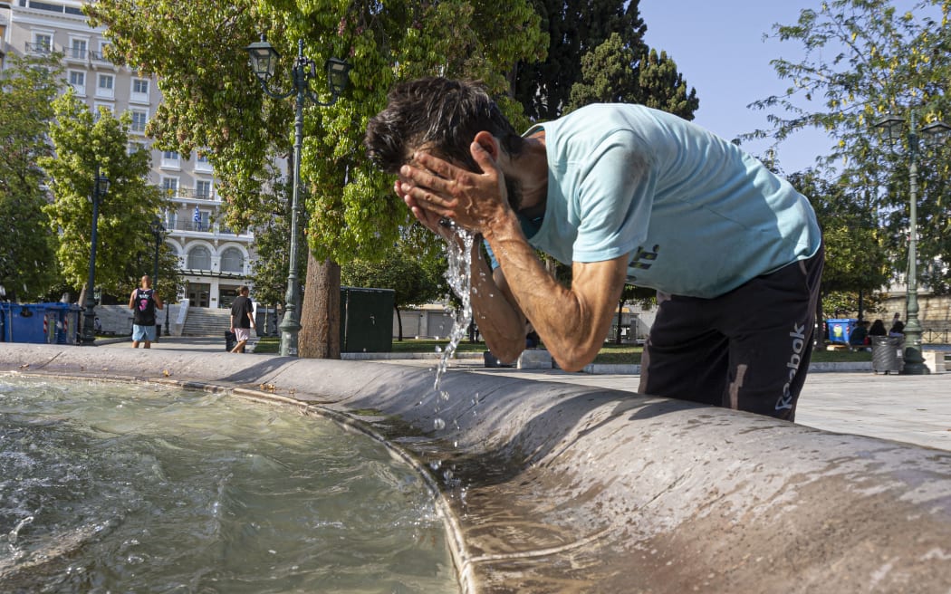 A man as seen splashing his face with water from the fountain to cool down. Heatwave &quot;Cleon&quot; in Greece. Daily life scene with local people and tourists passing in front of the famous Syntagma square fountain while they try to cool off with water from it and shadow under the trees as temperatures rise and exceed 40° degrees Celsius. Athens, Greece on July 15, 2023 (Photo by Nicolas Economou/NurPhoto) (Photo by Nicolas Economou / NurPhoto / NurPhoto via AFP)