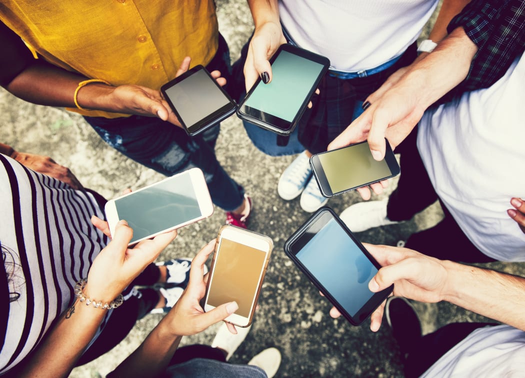 Diverse friends using their phones.