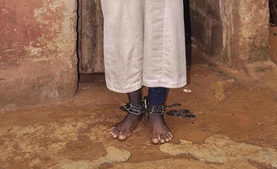 EDITORS NOTE: Graphic content / A man stands with chains on his ankles and wrists on September 26, 2019 in the Rigasa area of Kaduna in northern Nigeria where 300 male students of "different nationalities" were rescued by police from an Islamic seminary where they were tortured and sodomised. -