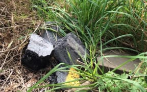Rubble from road works pictured beside a stream.