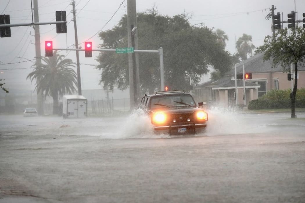 ALVESTON, TX - AUGUST 26: A vehicle navigates a street flooded by rain from Hurricane Harvey on August 26, 2017 in Galveston, Texas.