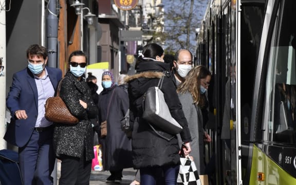 People wearing protective face masks as a measure against the spread of the Covid-19 (novel coronavirus) pandemic, take a tramway on October 22, 2020 in a street of Saint-Etienne, central eastern France.