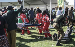 Injured people are evacuated after an explosion at the stadium in Bulawayo where Zimbabwe President just addressed a rally.