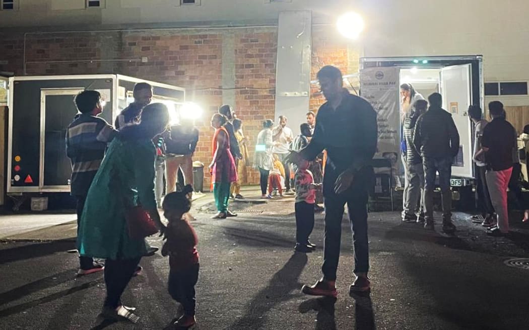 Customers gather around food trucks at a night market in Auckland. SINGLE USE ONLY