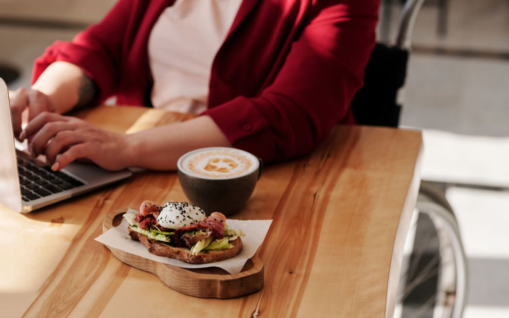woman in wheelchair with coffee and food