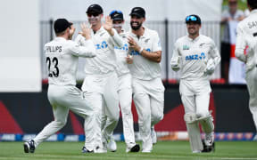 New Zealand's Glenn Phillips, Will Young, Tom Latham and Daryl Mitchell celebrate the wicket of England's Joe Root on the second day of the third cricket test at Seddon Park in Hamilton, 15 December, 2024.