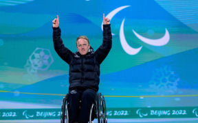 Corey Peters NZL celebrates on the podium after winning gold in the Men’s Downhill Sitting Para Alpine Skiing, 2022 Winter Paralympic Games.