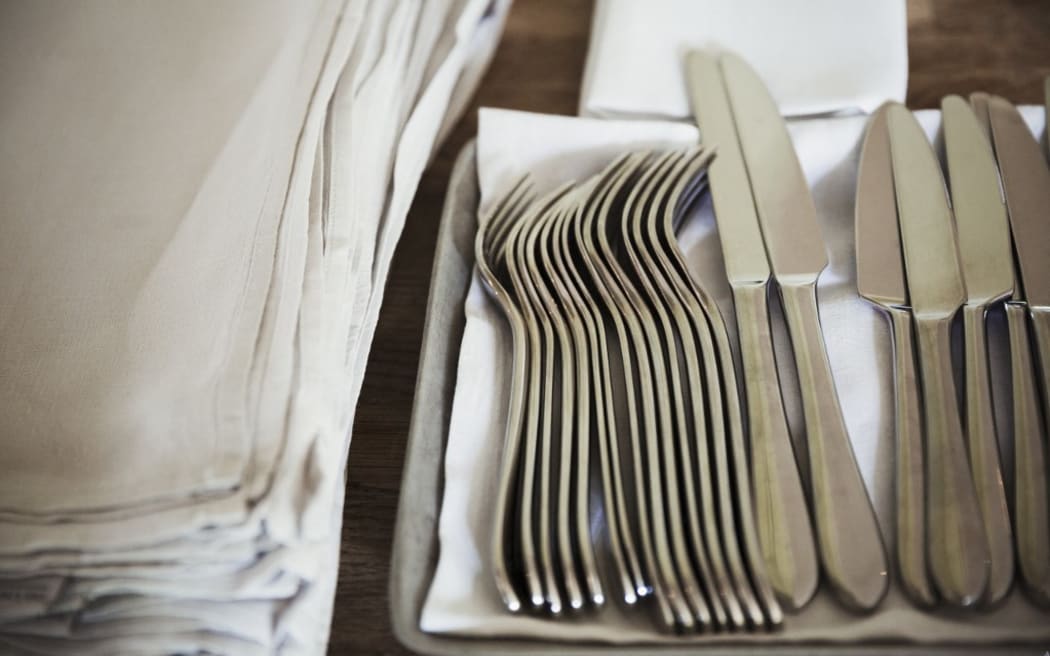 [England] High angle close up of napkins and silver forks and knives on a table in a restaurant. (Photo by Mint Images / Mint Images / Mint Images via AFP)