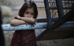 A Syrian girl looks on in the city of Hamouria in Damascus province on the third day of Eid al-Adha celebrations on September 26, 2015.