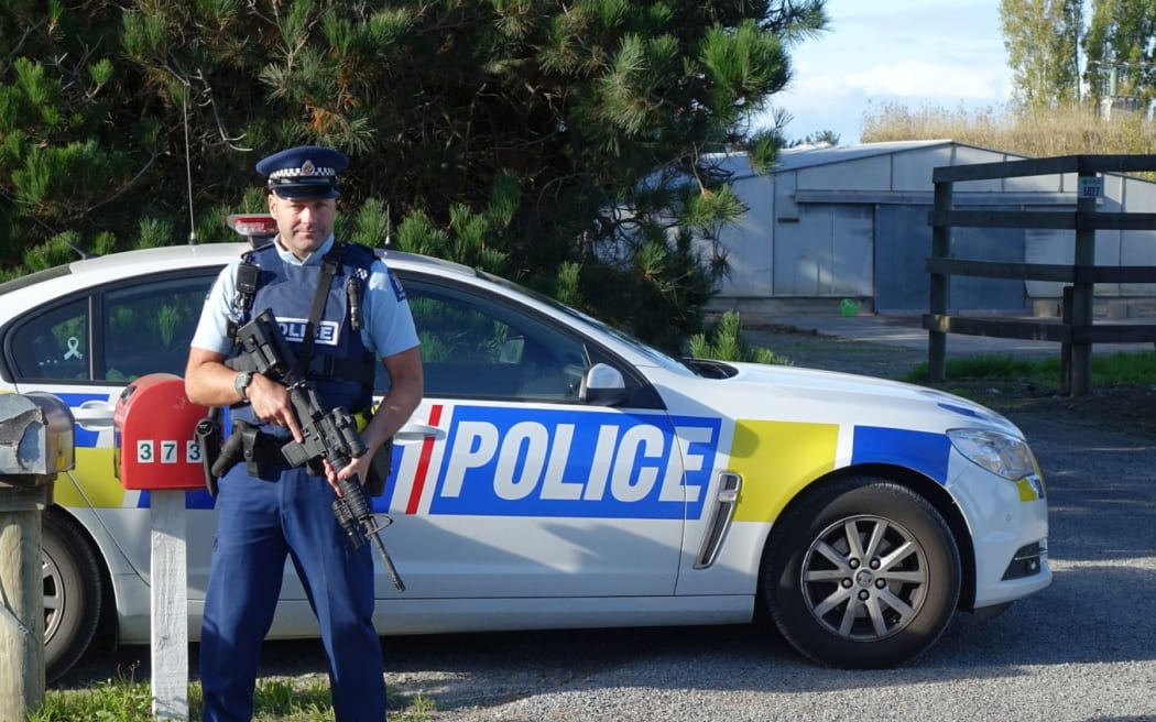 A police officer stands guard outside the property where two people were shot.