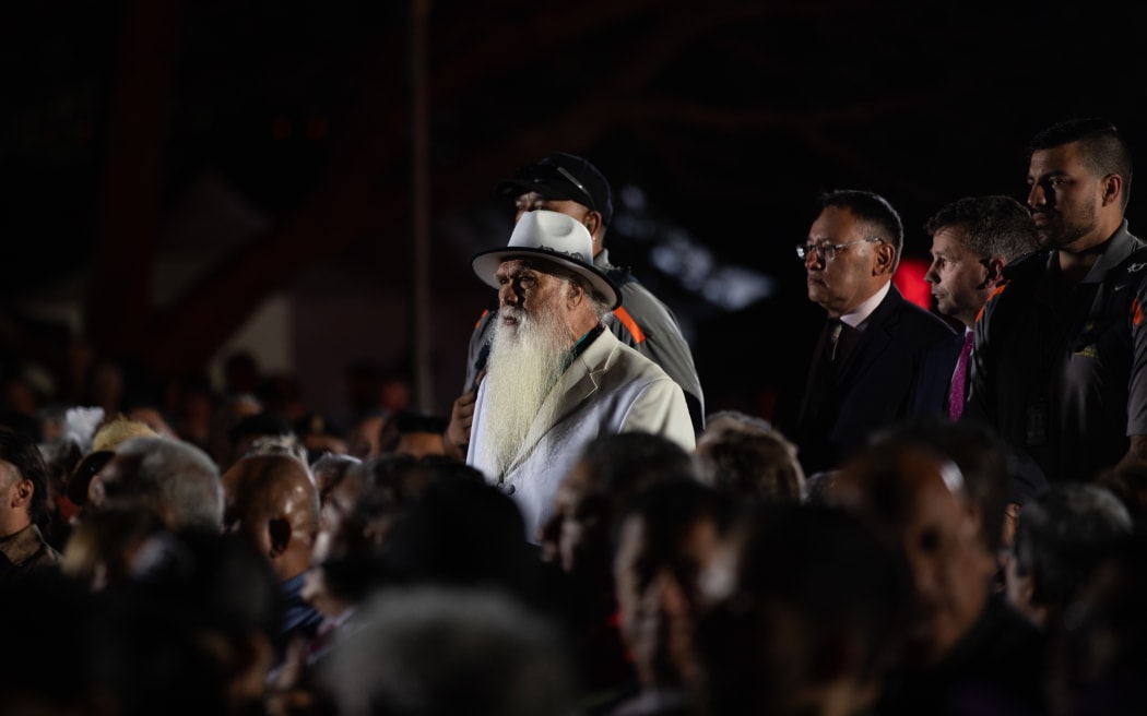 Hone Sadler walks on Shane Reti and David Seymour at the dawn service on Waitangi Day