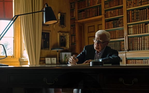 Movie still from the documentary film The Pigeon Tunnel showing the author John Le Carré at a writing desk