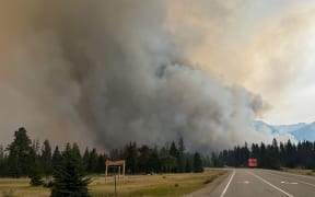 In this July 24, 2024, image obtained from the Jasper National Park in Canada, smoke rises from a wildfire burning in the park. The "out of control" wildfire has devoured up to half of the main town in western Canada's popular Jasper National Park, authorities said July 25, with 400 foreign firefighters called in to help battle the blaze. (Photo by Handout / Jasper National Park / AFP)