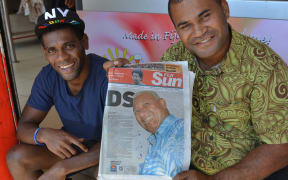 Fiji First Party supporters hold up a local newspaper showing a front page photograph of Frank Bainimarama a day after the Fiji elections.
