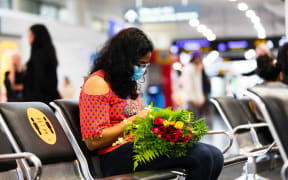 A woman waiting at Auckland Airport for passengers to disembark from the first flight from Sydney to Auckland under the trans-Tasman bubble arrangement.
