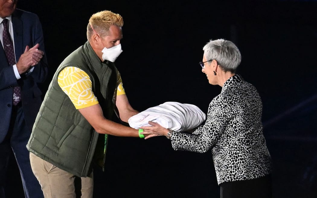 Australian athlete Barry Lester hands over the Commonwealth Flag to the Governor of Victoria Linda Dessau during the Closing Ceremony of the XXII Commonwealth Games in Birmingham, 2022.