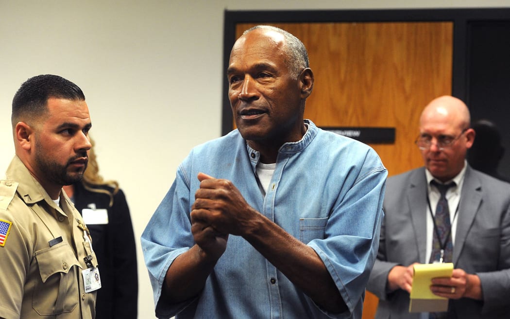 O.J. Simpson (C) reacts after learning he was granted parole during his parole hearing at the Lovelock Correctional Center in Lovelock, Nevada on July 20, 2017. Disgraced former American football star O.J. Simpson was granted his release from prison on Thursday after serving nearly nine years behind bars for armed robbery.A four-member parole board in the western US state of Nevada voted unanimously to free the 70-year-old Simpson after a public hearing broadcast live by US television networks. (Photo by Jason Bean / POOL / AFP)