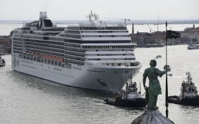 This picture taken on June 9, 2019 shows a MSC Magnifica cruise ship, seen from San Maggiore's bell tower, arriving in the Venice Lagoon carried by three tugboats.